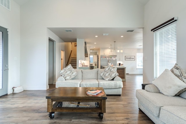 living room featuring hardwood / wood-style flooring, sink, and a high ceiling