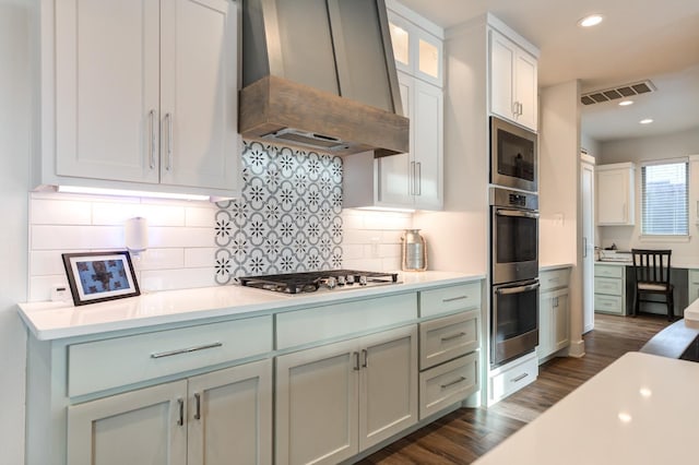 kitchen featuring white cabinetry, stainless steel appliances, dark hardwood / wood-style flooring, and custom exhaust hood