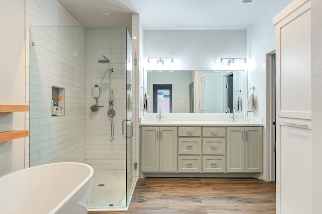 bathroom featuring vanity, wood-type flooring, and shower with separate bathtub