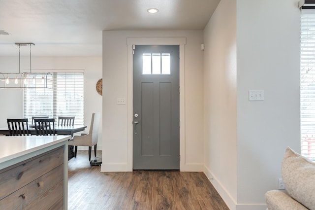 entryway with a notable chandelier and dark hardwood / wood-style floors