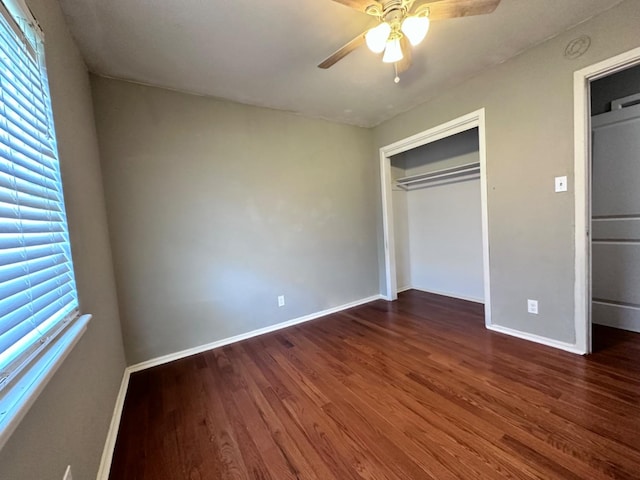 unfurnished bedroom with a closet, dark hardwood / wood-style floors, and ceiling fan