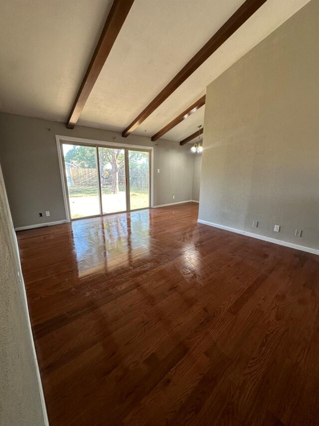 unfurnished room featuring lofted ceiling with beams, wood-type flooring, and a chandelier