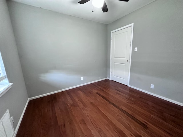 spare room featuring dark wood-type flooring and ceiling fan