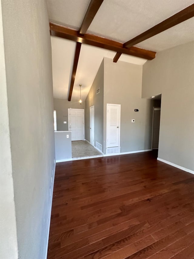 unfurnished living room with dark wood-type flooring and lofted ceiling with beams