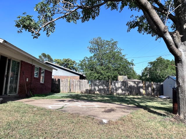 view of yard featuring a shed and a patio area