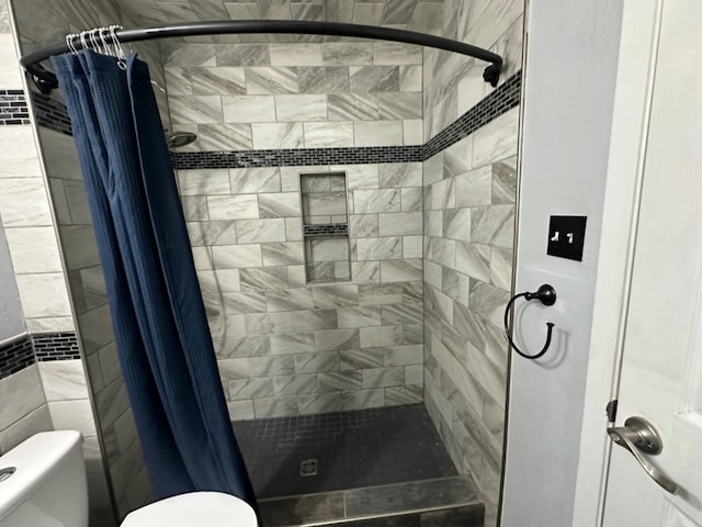 bathroom featuring toilet and a shower with shower curtain