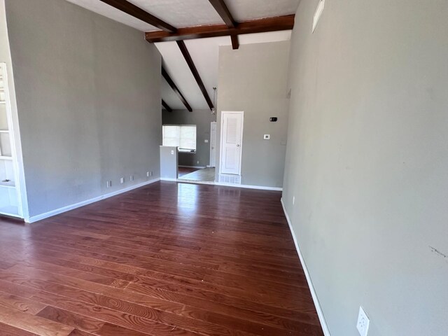 unfurnished living room featuring beamed ceiling, dark hardwood / wood-style flooring, and high vaulted ceiling