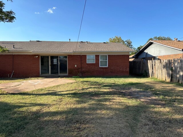 rear view of house with a yard and a patio area