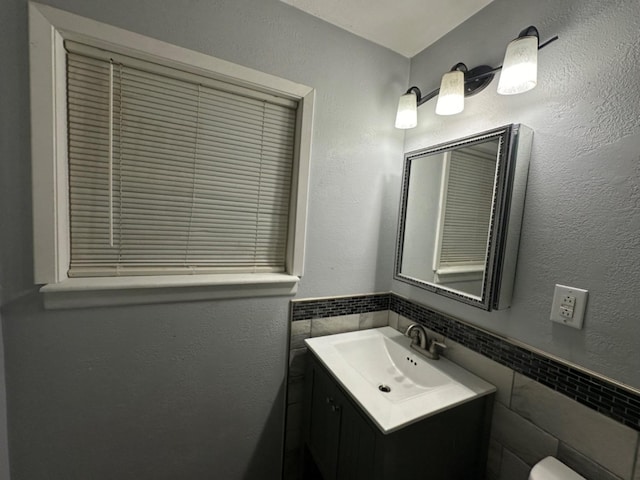 bathroom with vanity and tile walls