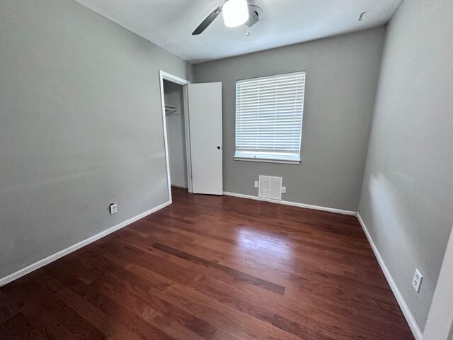 unfurnished bedroom with dark wood-type flooring and ceiling fan