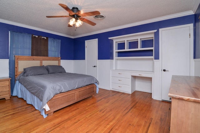 2911 US Highway 385, Littlefield, TX 79339 - bedroom featuring crown molding, light hardwood / wood-style flooring, ceiling fan, built in desk, and a textured ceiling