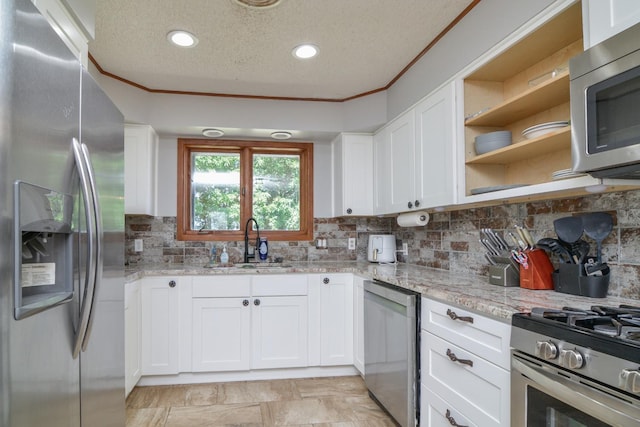 2911 US Highway 385, Littlefield, TX 79339 - kitchen featuring white cabinetry, sink, light stone counters, and appliances with stainless steel finishes