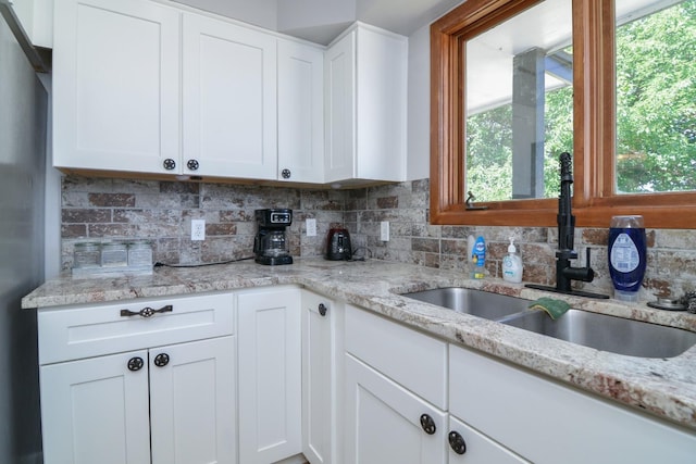 2911 US Highway 385, Littlefield, TX 79339 - kitchen featuring white cabinetry, sink, and decorative backsplash