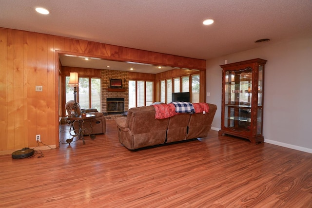 2911 US Highway 385, Littlefield, TX 79339 - living room featuring wood-type flooring, a brick fireplace, and wood walls