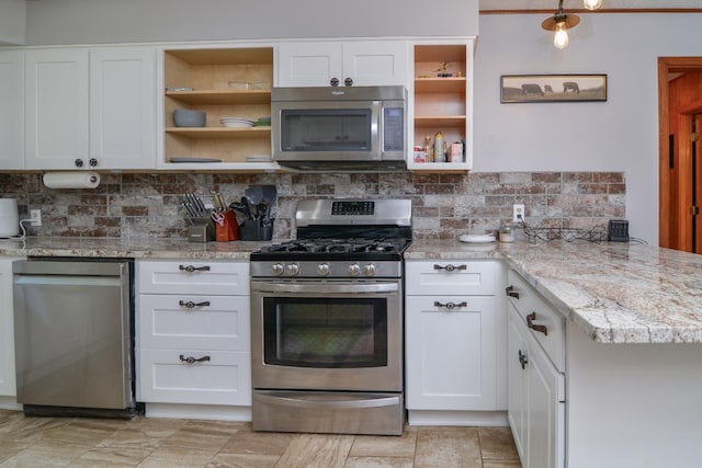 2911 US Highway 385, Littlefield, TX 79339 - kitchen with tasteful backsplash, light stone countertops, white cabinets, and appliances with stainless steel finishes