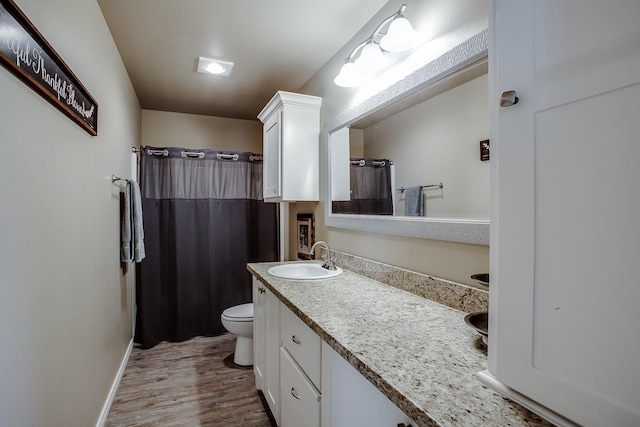 bathroom with hardwood / wood-style flooring, vanity, a shower with shower curtain, and toilet