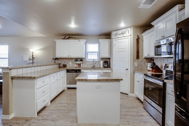 kitchen featuring white cabinetry, appliances with stainless steel finishes, and a center island