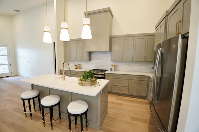 3628 119th St, Lubbock, TX 79423 - kitchen with appliances with stainless steel finishes, gray cabinets, a high ceiling, light wood-type flooring, and backsplash