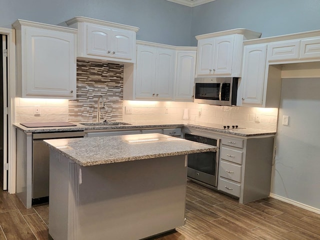 kitchen featuring sink, stainless steel appliances, white cabinets, and a kitchen island