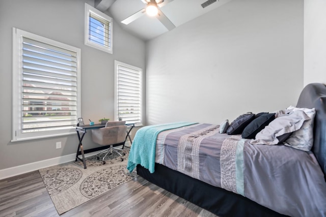 bedroom featuring multiple windows, hardwood / wood-style flooring, high vaulted ceiling, and ceiling fan