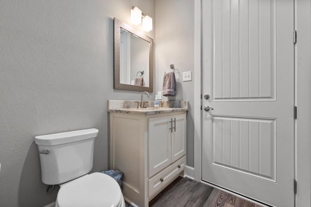 bathroom featuring vanity, toilet, and wood-type flooring