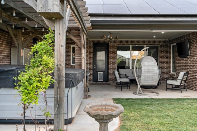 property entrance featuring ceiling fan, a patio area, and solar panels