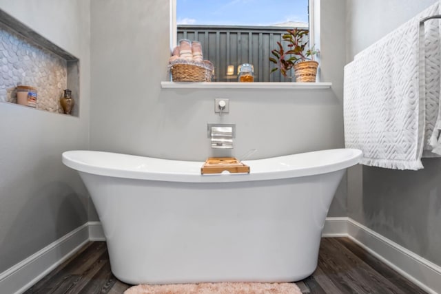 bathroom featuring wood-type flooring and a washtub