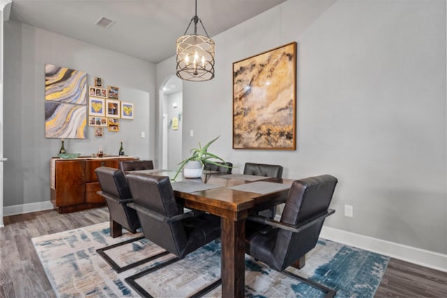 dining room with hardwood / wood-style flooring and a notable chandelier