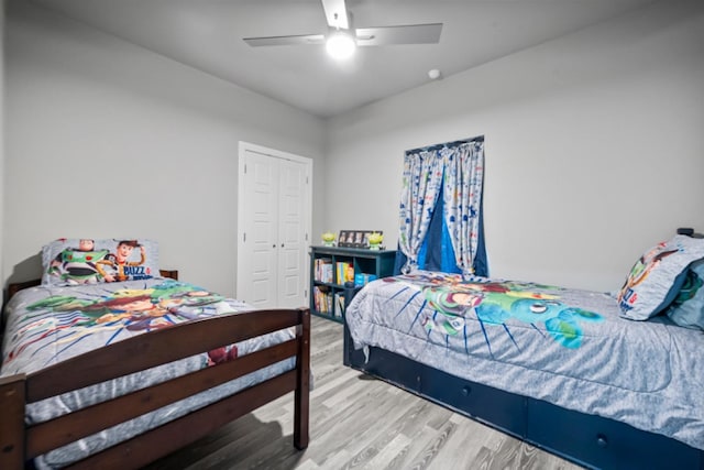 bedroom featuring ceiling fan, light wood-type flooring, and a closet