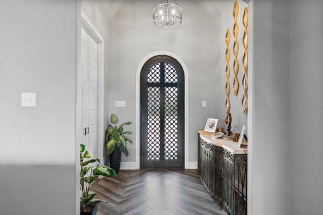 foyer featuring french doors, parquet flooring, and a chandelier