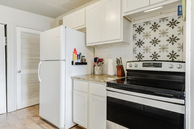 kitchen featuring white cabinets, white fridge, decorative backsplash, and electric stove