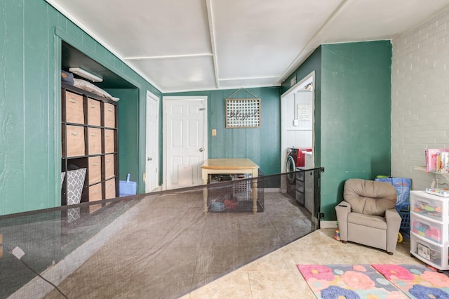 playroom with tile patterned floors and brick wall