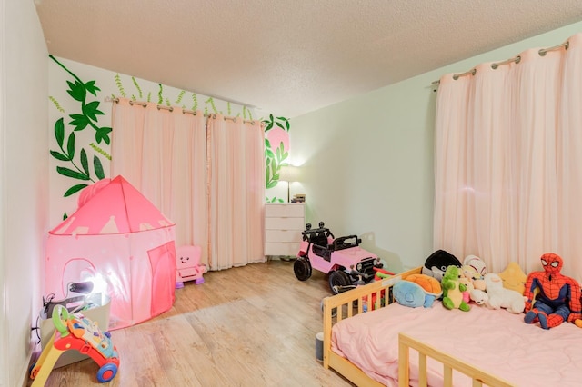 bedroom featuring hardwood / wood-style floors and a textured ceiling