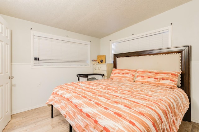 bedroom with light hardwood / wood-style floors and a textured ceiling