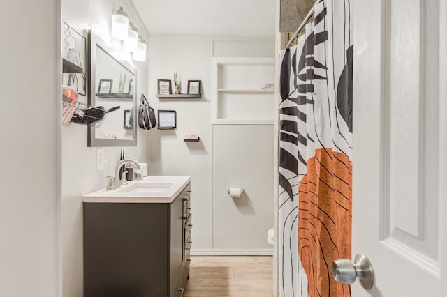 bathroom featuring vanity, wood-type flooring, and toilet