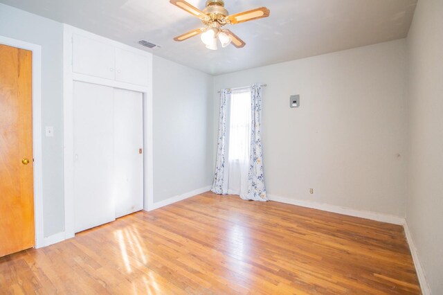 unfurnished bedroom with light hardwood / wood-style flooring, a closet, and ceiling fan