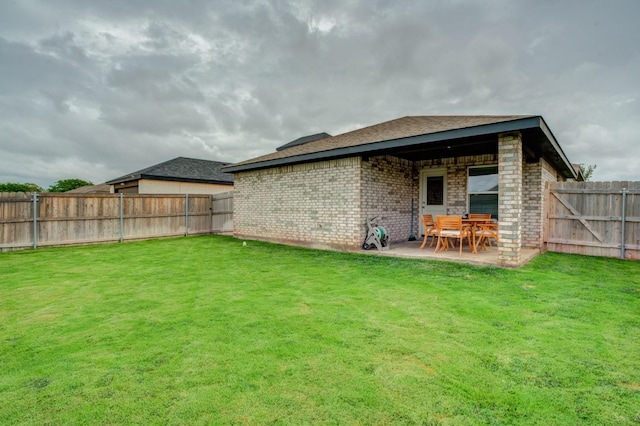 rear view of house featuring a yard and a patio