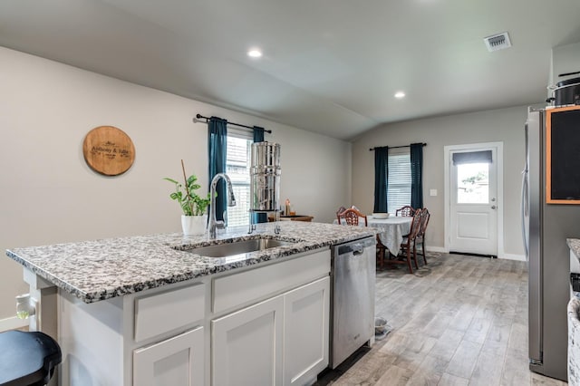 kitchen featuring sink, a center island with sink, light wood-type flooring, stainless steel appliances, and white cabinets