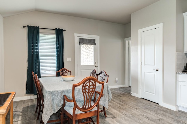 dining area with lofted ceiling and light hardwood / wood-style floors