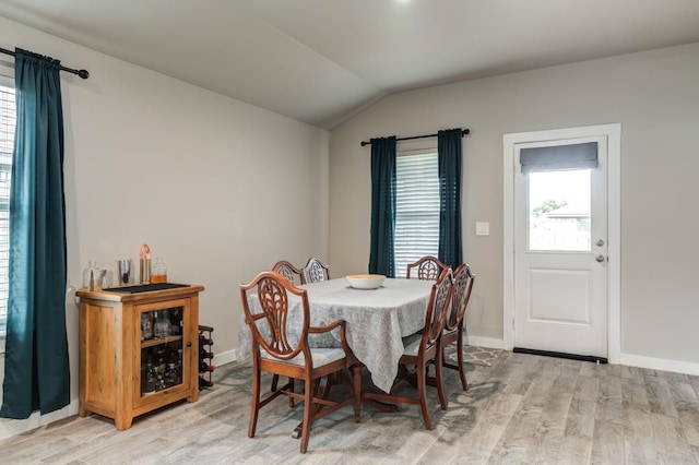 dining room featuring vaulted ceiling and light wood-type flooring