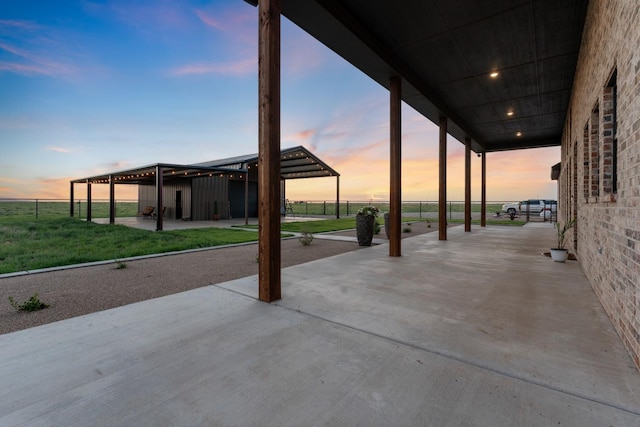 patio terrace at dusk featuring a yard