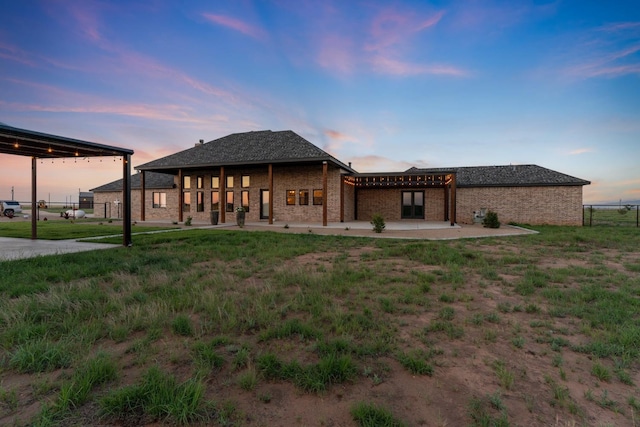 back house at dusk with a patio area