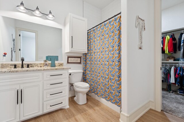 bathroom with hardwood / wood-style flooring, vanity, toilet, and a shower with shower curtain