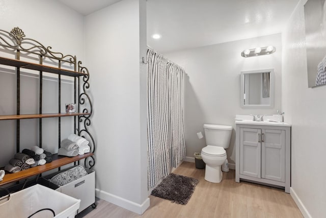 bathroom with vanity, wood-type flooring, walk in shower, and toilet