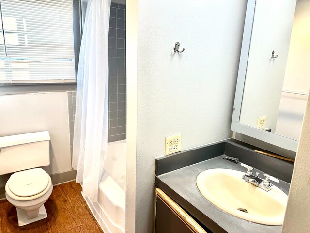 full bathroom featuring vanity, toilet, hardwood / wood-style floors, and shower / bath combo with shower curtain