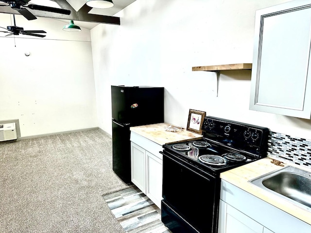 kitchen featuring sink, ceiling fan, black appliances, white cabinets, and light colored carpet