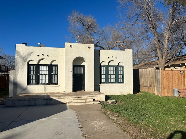 adobe home featuring a front yard