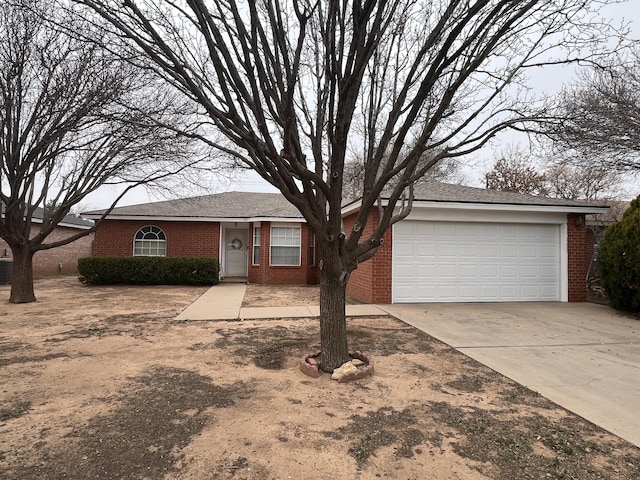 single story home with concrete driveway, a garage, and brick siding