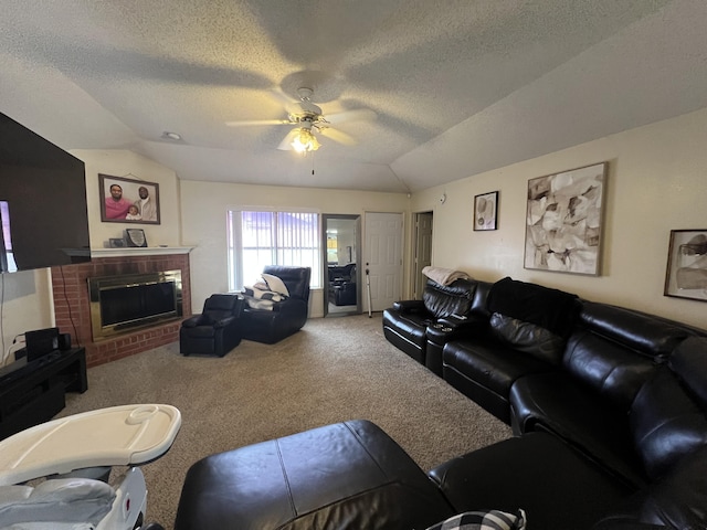 living area with carpet, ceiling fan, vaulted ceiling, a textured ceiling, and a brick fireplace