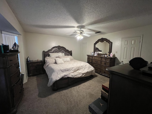 bedroom featuring a textured ceiling, dark colored carpet, and ceiling fan